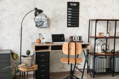 Ofisinde dizüstü bilgisayarı ve yapılacaklar listesi olan modern işyeri