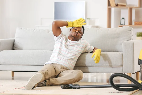 Zmęczony Afroamerykanin Odpoczywający Sprzątaniu Mieszkania — Zdjęcie stockowe