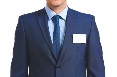 Beyaz arka planda boş rozeti olan şık takım elbiseli adam.