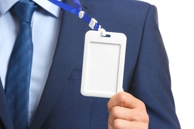 Beyaz arka planda boş rozetli şık takım elbiseli adam, yakın plan.