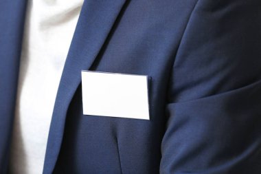 Boş rozetli şık takım elbiseli adam, yakın plan.