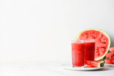 Beyaz arka planda taze karpuz suyu olan bardaklar.