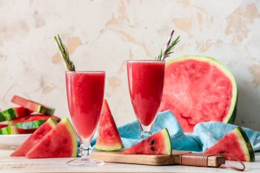 Açık arkaplanda taze karpuz suyu olan bardaklar.