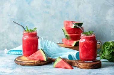 Arka planda taze karpuz suyu olan Mason kavanozları.