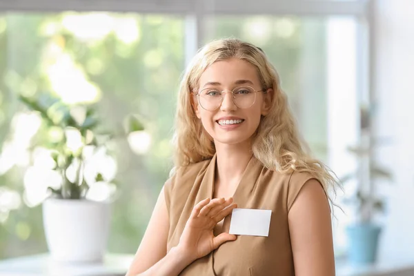 Young woman with blank badge in office