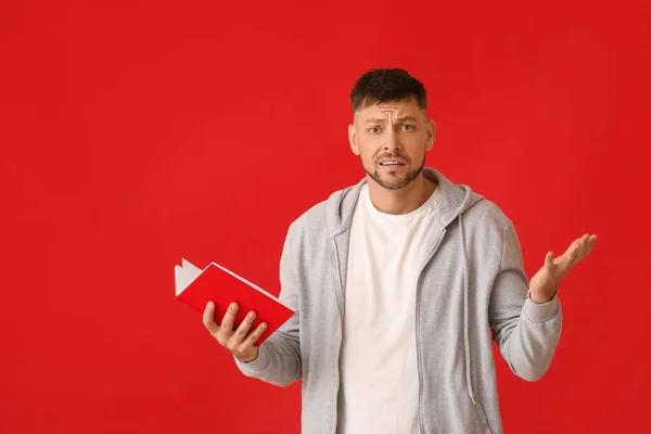 Hombre Confundido Con Libro Sobre Fondo Color —  Fotos de Stock