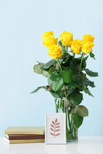 Ваза Красивими Жовтими Трояндами Книгами Рамкою Столі Кольоровому Фоні — стокове фото