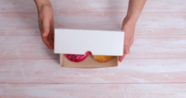 Женщина Открывает Коробку Вкусными Пончиками Столом Вид Сверху — стоковое видео
