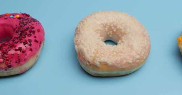 颜色背景上的许多不同的甜甜圈 — 图库视频影像