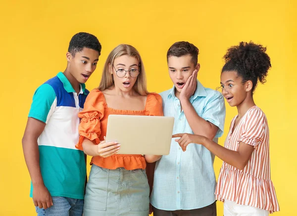 Adolescentes Sorprendidos Con Portátil Moderno Sobre Fondo Color — Foto de Stock