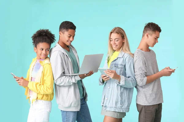 Teenagers with different devices on color background