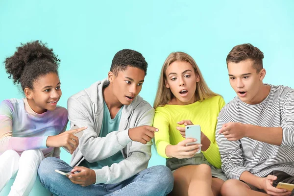 Adolescents Surpris Avec Des Téléphones Mobiles Modernes Sur Fond Couleur — Photo