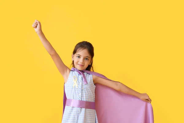 带着金色缎带的小女孩穿着超级英雄的服装 背景是彩色的 儿童癌症意识概念 — 图库照片