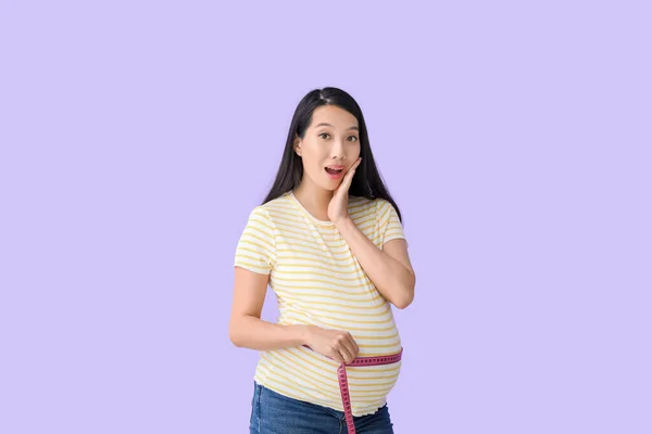 Surprised Pregnant Asian Woman Measuring Her Belly Color Background — Stock Photo, Image