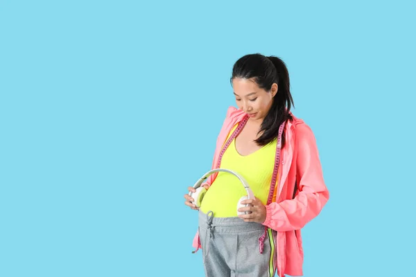 Pregnant Asian Woman Putting Headphones Her Belly Color Background — Stock Photo, Image