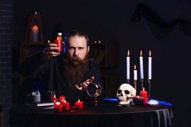 Masasında mumu olan bir erkek falcı.