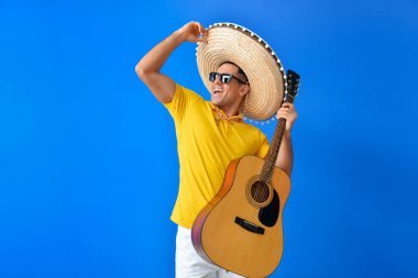 Sombrero şapkalı yakışıklı ve gitarlı genç bir adam.