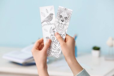 Evde sevimli kitap ayracı olan bir kadın.