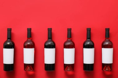 Renkli arka planda boş etiketli şarap şişeleri
