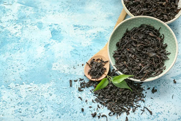Száraz Fekete Tea Levelek Tálak Kanál Színes Háttér — Stock Fotó