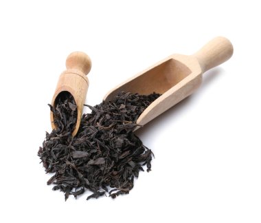 Beyaz arka planda kepçe ile kuru siyah çay yaprakları yığını