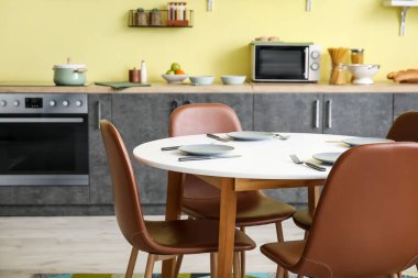 Modern mutfağın içinde yemek masası ve sandalyeler.