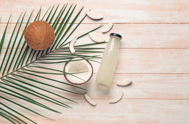 Ahşap zemin üzerinde taze hindistan cevizi suyu şişesi olan kompozisyon