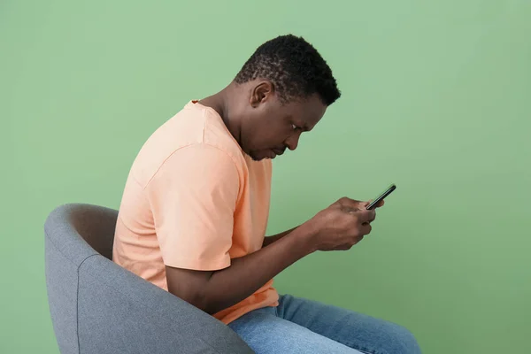 Hombre Afroamericano Jorobado Con Teléfono Móvil Sentado Silla Cerca Pared — Foto de Stock