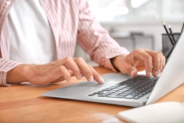 Evde dizüstü bilgisayarı olan genç bir adam.