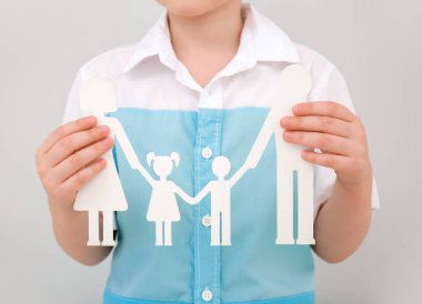 Işık arka planında insan figürleri tutan çocuk