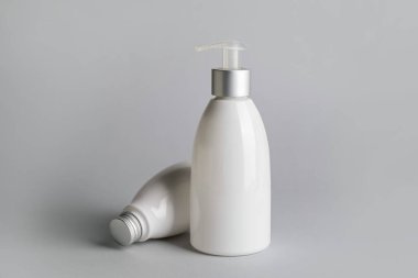 Gri arka planda farklı kozmetik ürünleri şişeleri