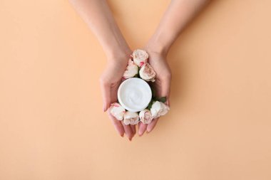 Kremalı ve güzel çiçekli genç bir kadının elleri.