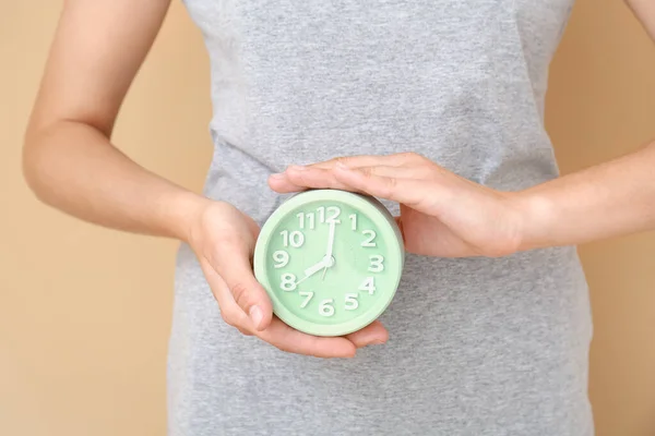 Mujer Sosteniendo Reloj Despertador Sobre Fondo Color — Foto de Stock