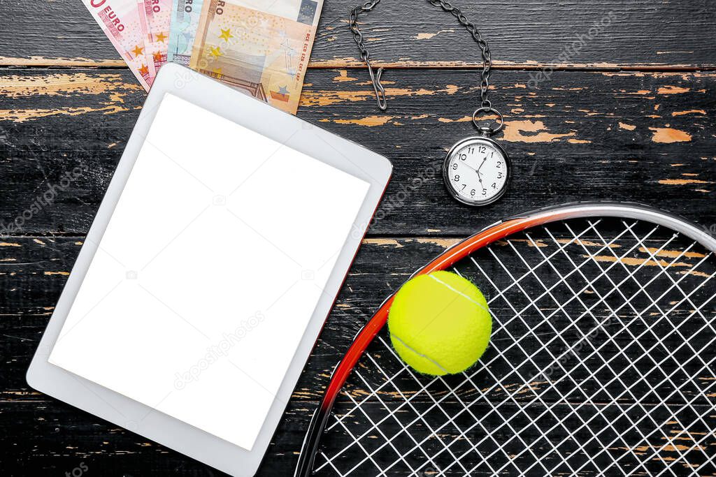 Money, tablet computer and tennis rocket on wooden background