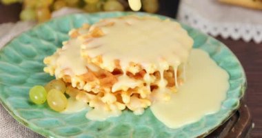 Lezzetli ev yapımı waffle 'ların üzerine konsantre süt dökülüyor.