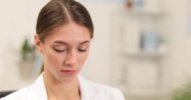 Kadın doktor klinikte tıbbi maske takıyor ve koruyucu gözlük takıyor.