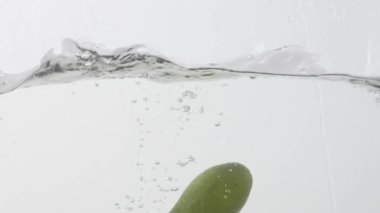 Taze avokadonun hafif arka planda suya düşmesi