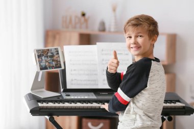 Küçük çocuk evde müzik dersleri alıyor.