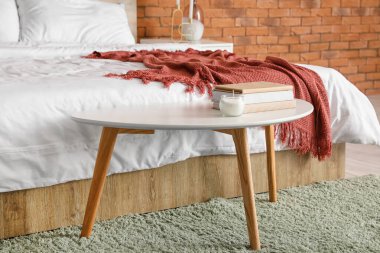 Yatak odasının içinde tuğla duvar var.