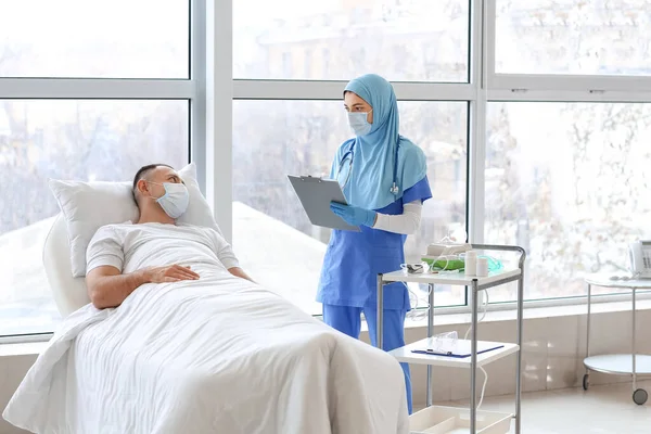 Female Muslim Doctor Visiting Male Patient Clinic — Stock Photo, Image