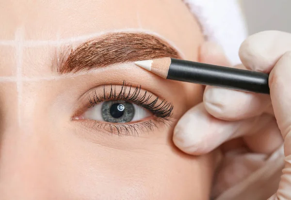 Young woman undergoing eyebrow correction procedure, closeup