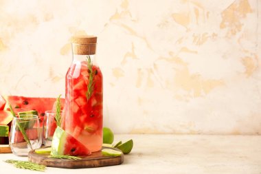 Masada bir şişe taze karpuz limonata ve bardaklar.