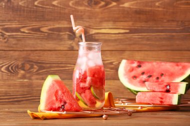 Ahşap arka planda bir şişe lezzetli soğuk karpuz limonatası.