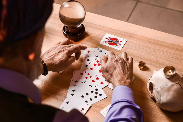 テーブルで未来を読むカード付き男性占い師 — ストック写真