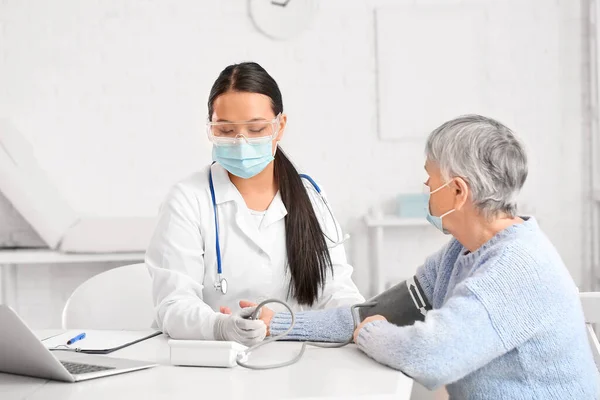 Doctor Measuring Blood Pressure Senior Woman Clinic — Stock Photo, Image