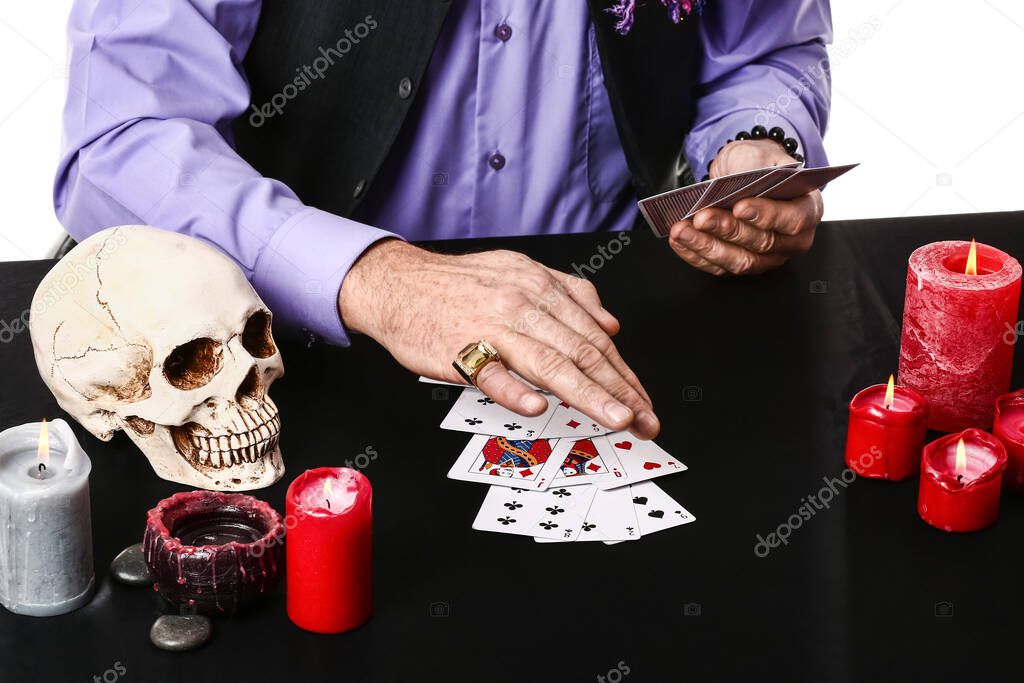 Male fortune teller with cards at table, closeup
