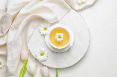 Aydınlık zemin üzerinde çay ve bahar çiçekleri olan güzel bir kompozisyon