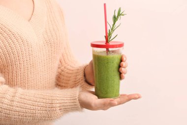 Hafif arka planda sağlıklı sebze suyu olan kadın, yakın plan.