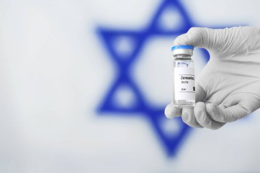 İsrail bayrağına karşı COVID-19 aşısıyla doktor eli