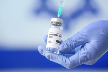 İsrail bayrağına karşı COVID-19 aşısıyla doktor eli